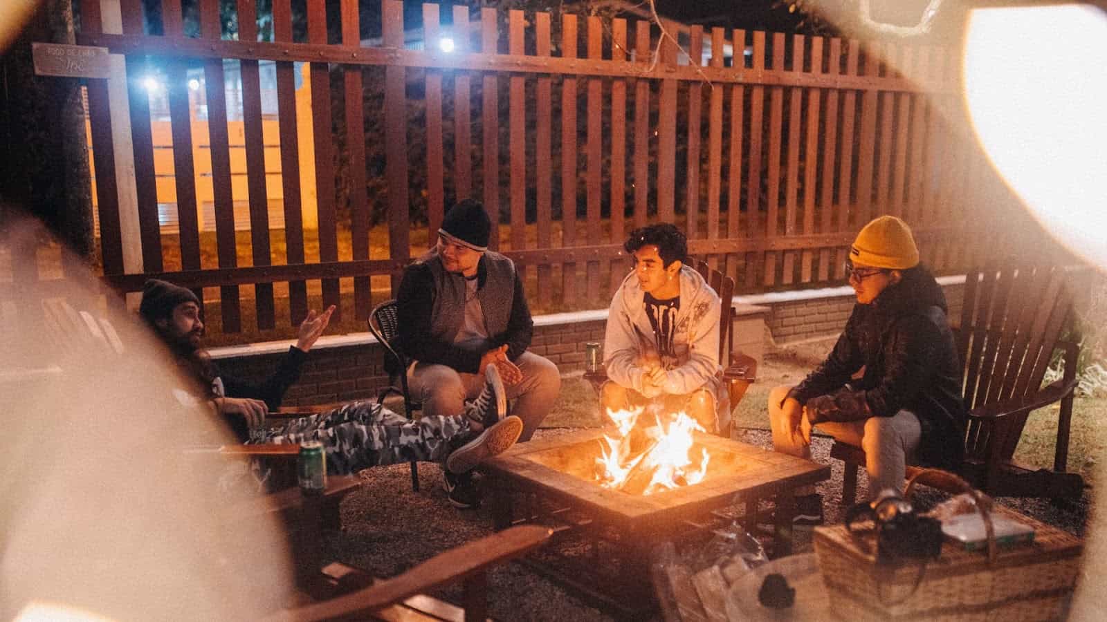 4個男生圍著篝火聊天