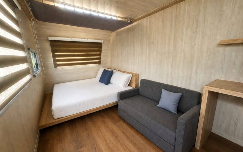 暖居露營車內部，有雙人床與沙發